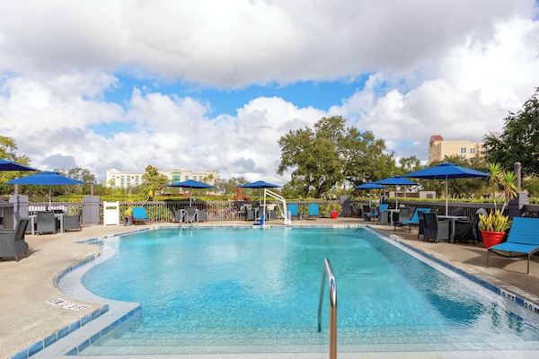 Una piscina al aire libre, sillones reclinables de piscina