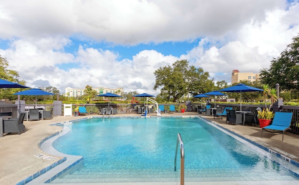 Una piscina al aire libre, sillones reclinables de piscina