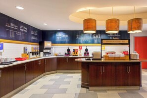 A modern kitchen with wooden cabinets, a central island, and a breakfast bar. - Hampton Inn Orlando-International Airport (Orlando)