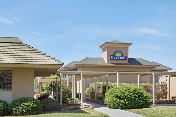 A Days Inn with a covered parking area and a landscaped garden. - Days Inn by Wyndham Charlotte/Woodlawn Near Carowinds (Charlotte)