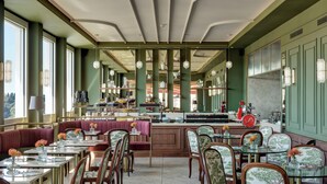 A restaurant with booths and tables, a bar area, and a view of the city. - Hotel Kraft (Florence)