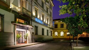 A hotel with a classic facade, a well-lit entrance, and a visible signboard. - Hotel Kraft (Florence)