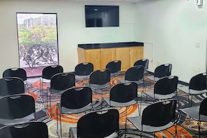 Conference room with a semi-circle seating arrangement and a large window offering views of the landscaped area.