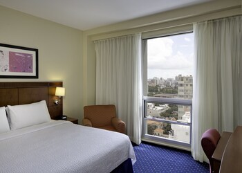 In-room safe, desk, blackout drapes, iron/ironing board at Courtyard by Marriott San Juan Miramar