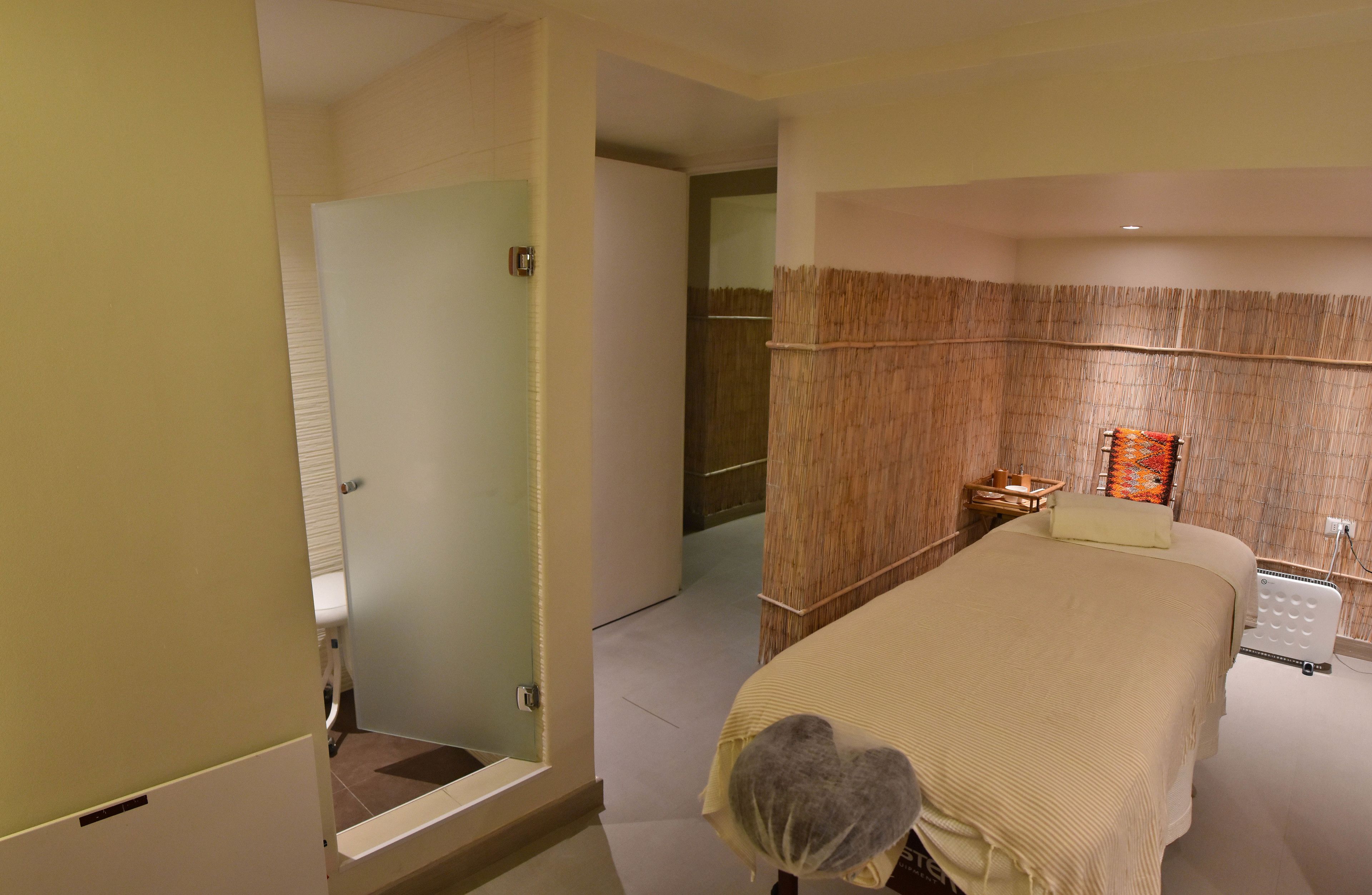 Ein Hotelzimmer mit einem großen Bett, einem Badezimmer mit Dusche und einer kleinen Sitzecke mit einem Korb.