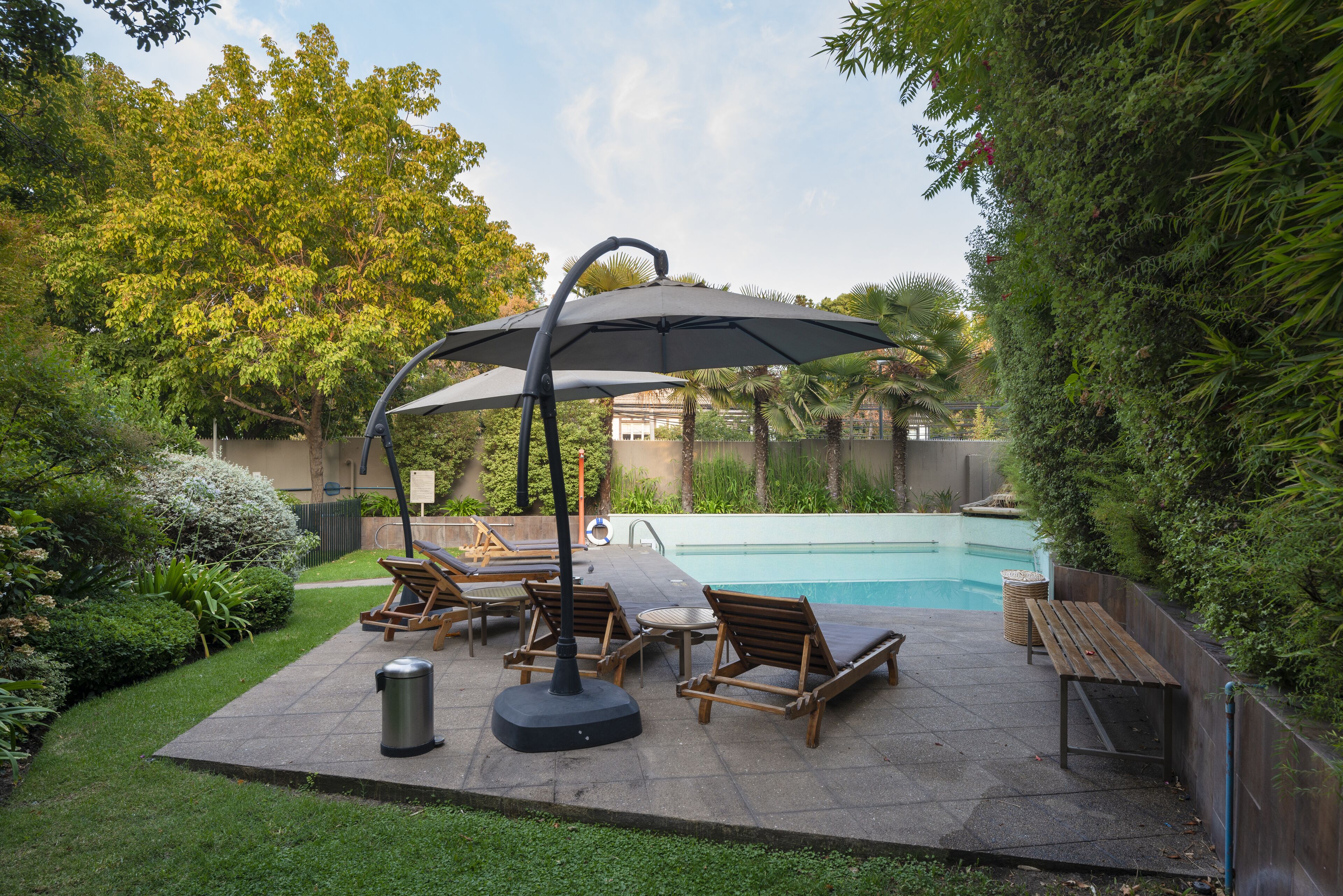 Una piscina al aire libre de temporada, sombrillas
