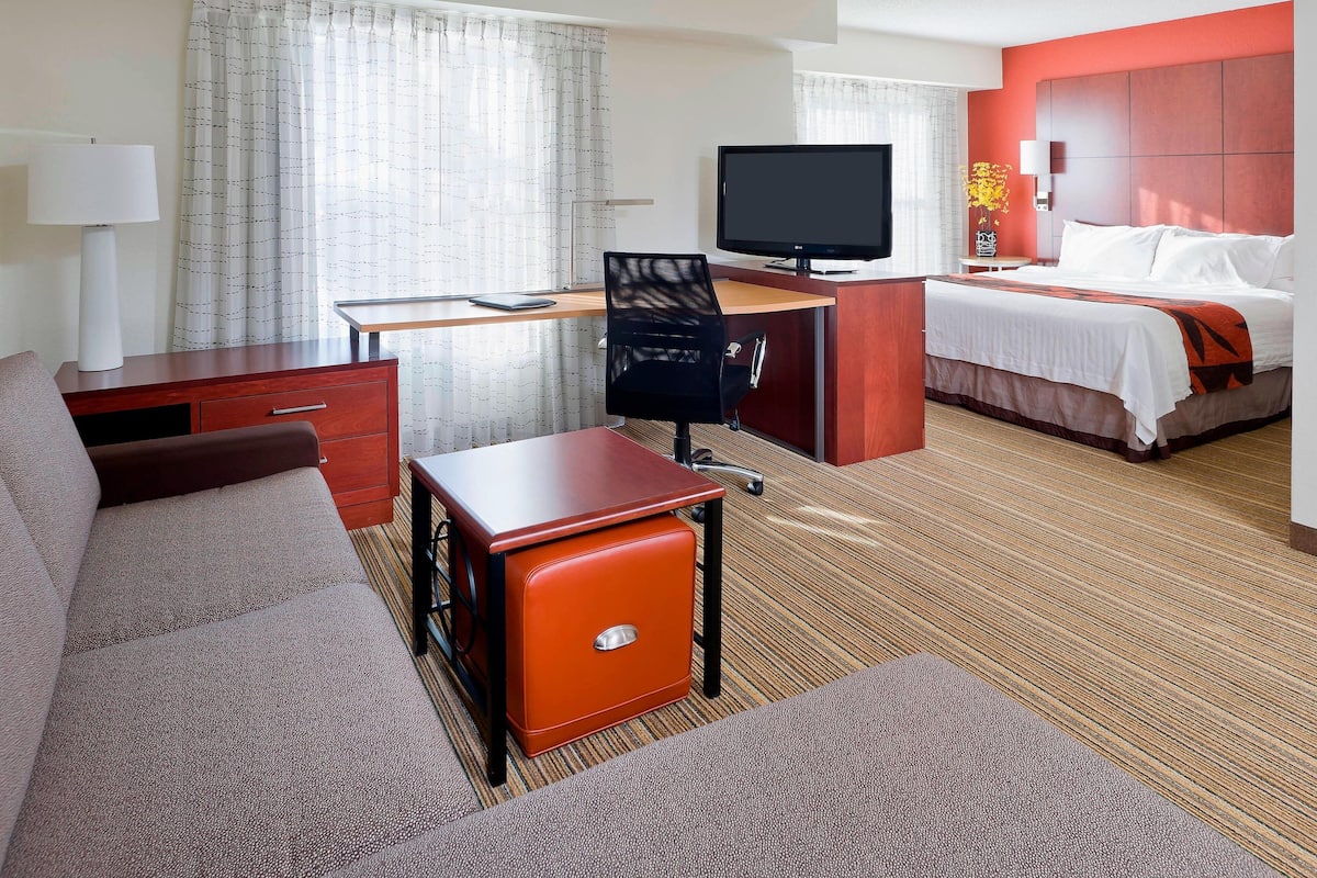 Escritorio, cortinas blackout y tabla de planchar con plancha