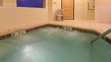 A swimming pool with a 3ft depth marker, a door, and a chair.