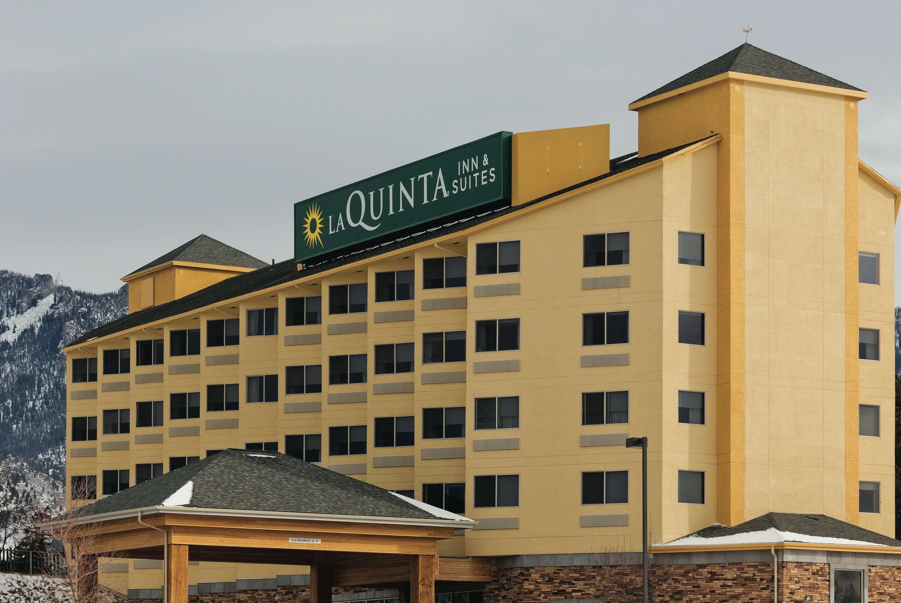 Edifici d'un La Quinta Inn & Suites amb façana groga, diverses finestres i zona d'entrada coberta.