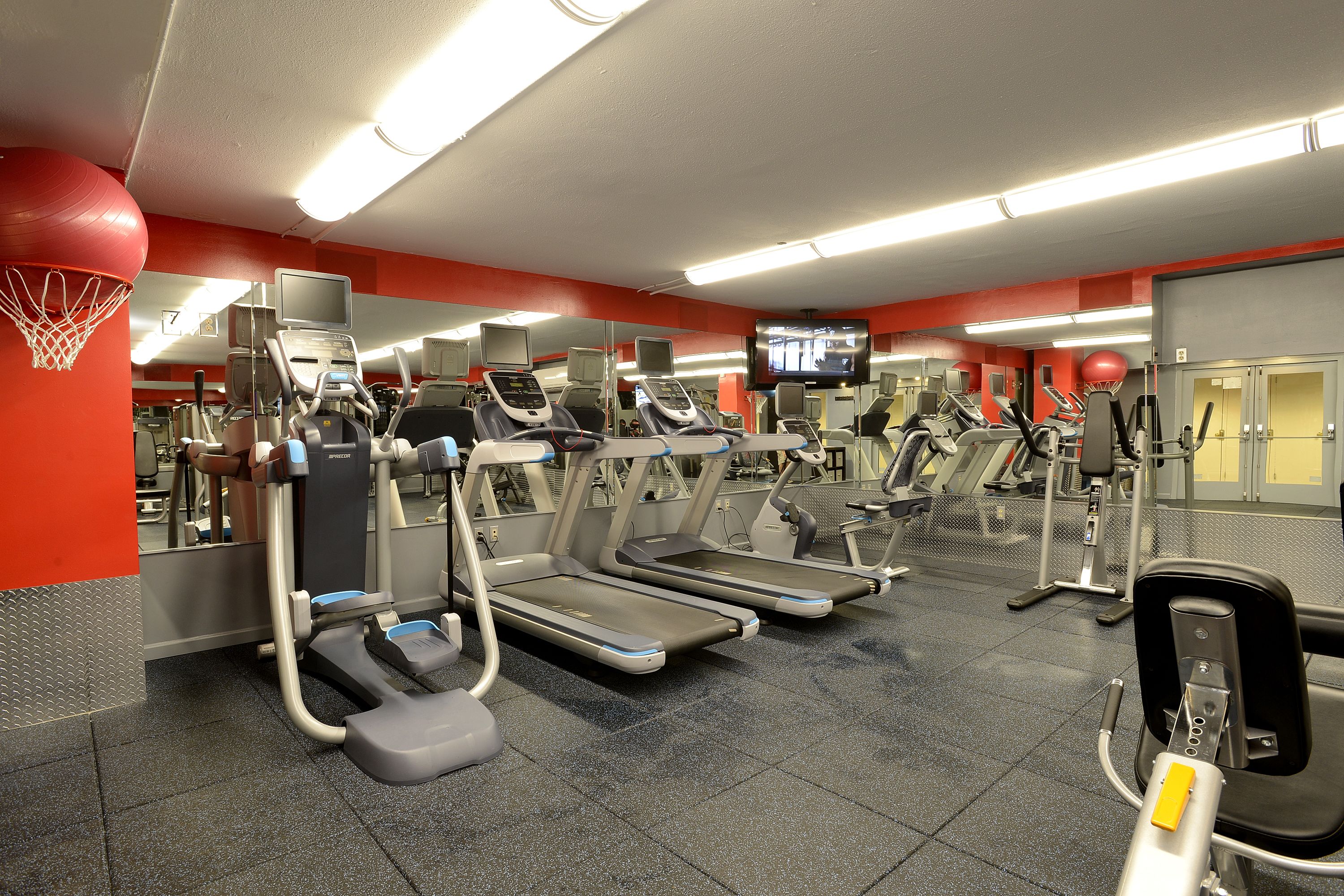 A gym with treadmills, elliptical machines, and weight equipment.