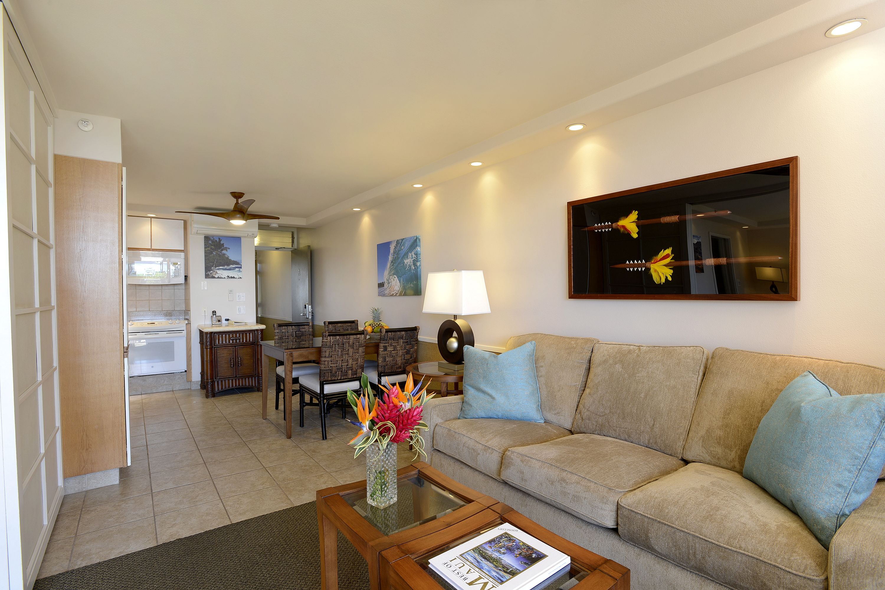 A living room with a sofa, coffee table, and a dining area with chairs and a table.