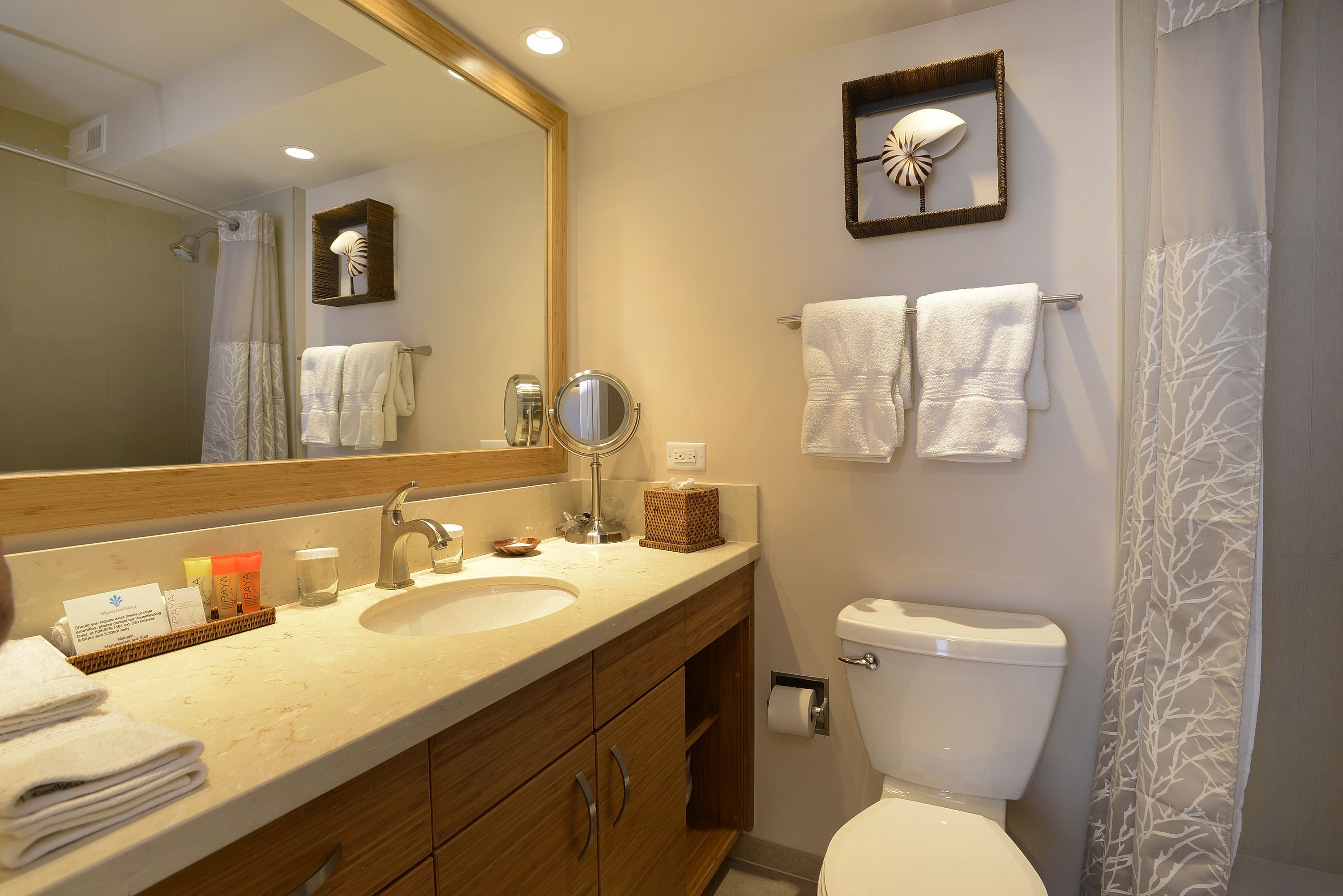 A bathroom with two sinks, a toilet, a large mirror, and a shower curtain.