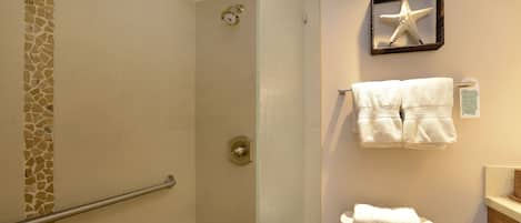 A bathroom with a shower, toilet, and towel rack.