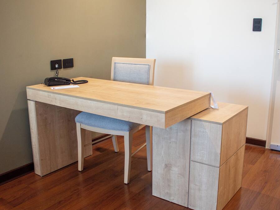A compact workspace with a desk, chair, and a small cabinet.