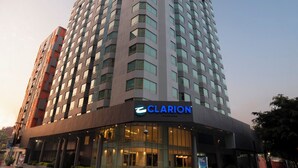 Un hotel alto de diseño moderno, con un llamativo letrero de 'CLARION' en la entrada.