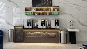 Ein modernes Café mit Espressomaschinen, einer Kaffeeausgabe und einem Regal mit Kaffeeprodukten.