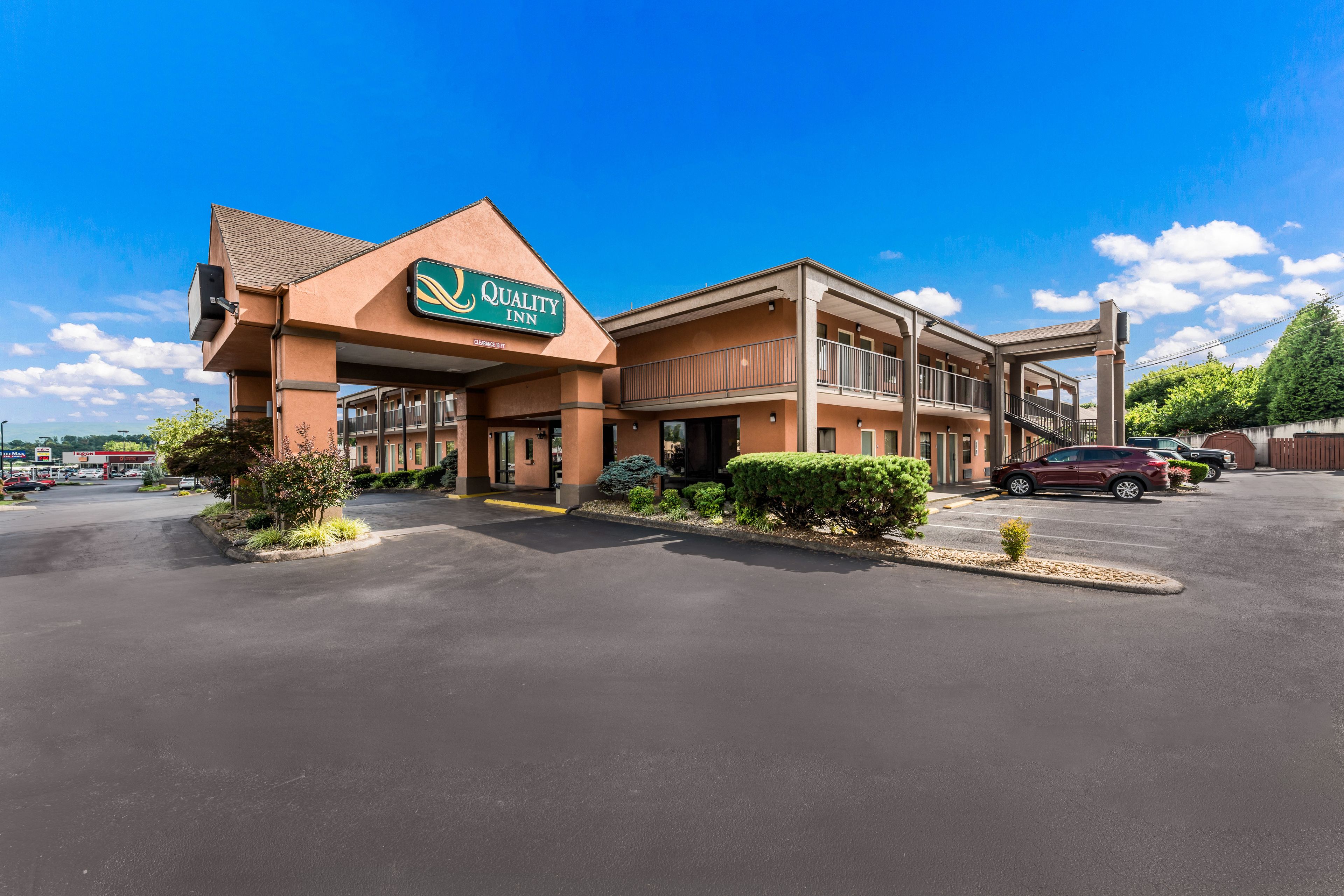 A Quality Inn hotel with a modern design, featuring a prominent sign, a parking lot, and a well-maintained exterior.