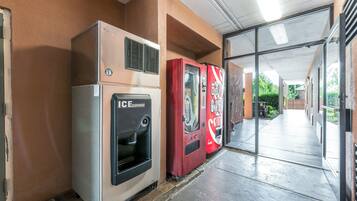 A hallway with an ice dispenser and two vending machines.