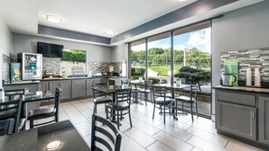 Una cocina moderna con comedor, ventanas amplias y vistas a zonas verdes.