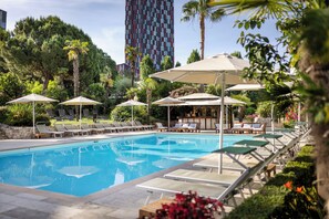Relax by the serene pool surrounded by lush greenery and comfortable lounge chairs.