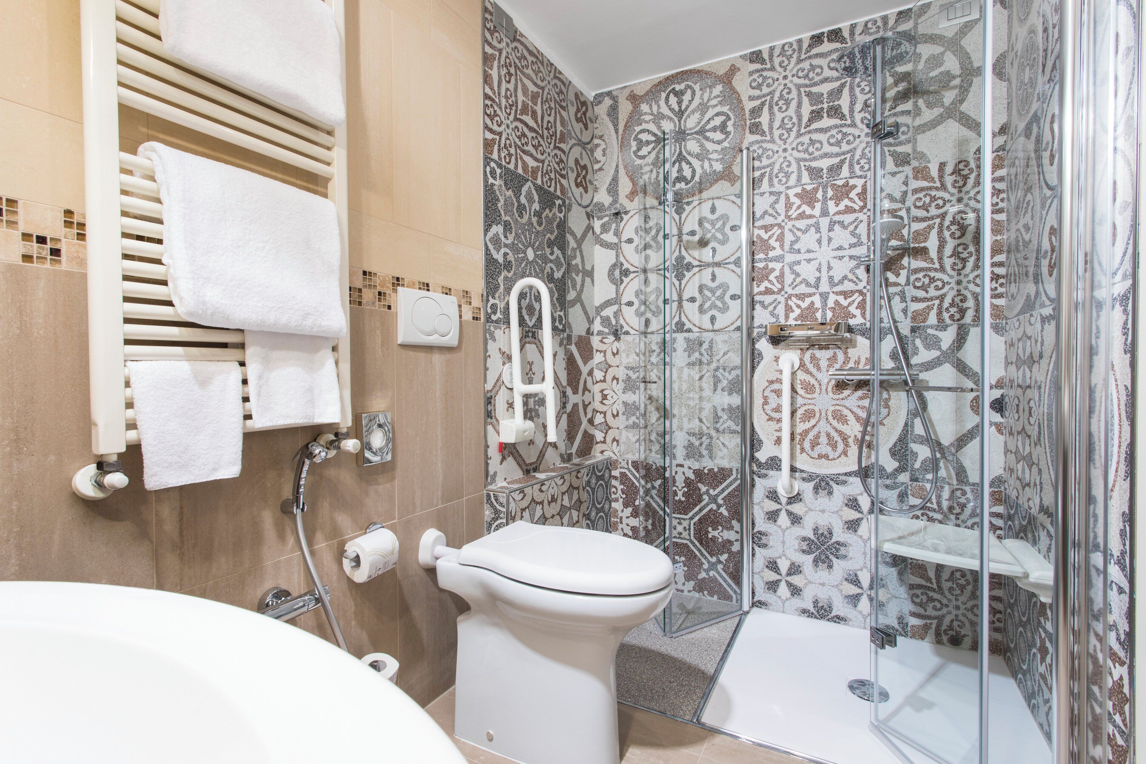 A bathroom with a shower, toilet, and bathtub.