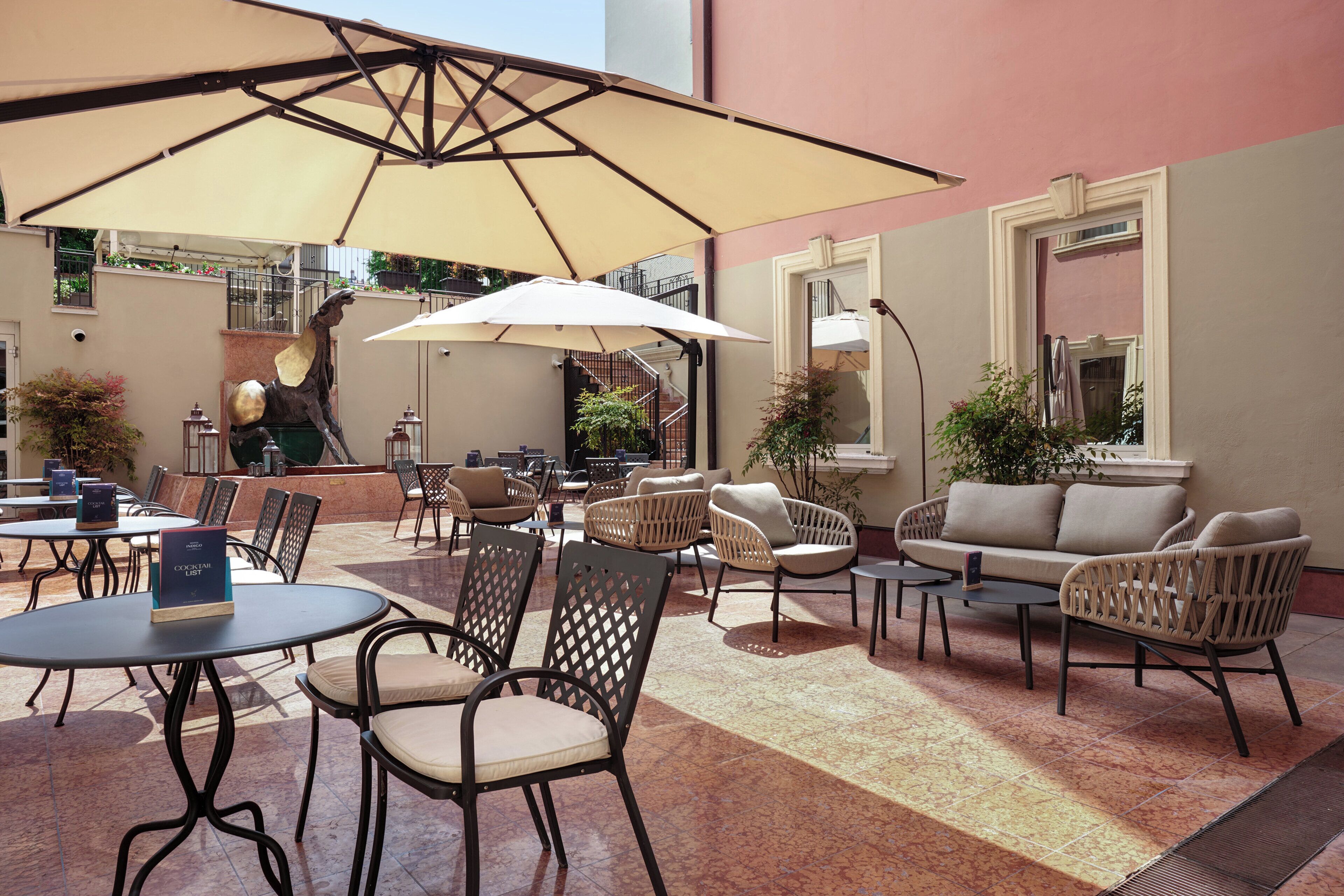 An outdoor seating area with tables, chairs, and umbrellas.