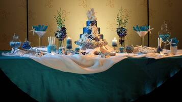 A table with a tiered cake, candles, and decorative items.