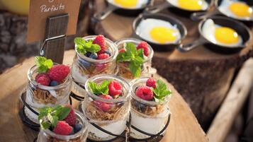 Jars of organic yogurt parfaits with raspberries and mint leaves, and a sign indicating the name.