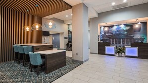 A modern reception area with a wooden reception desk, seating area, and a large wall mural.