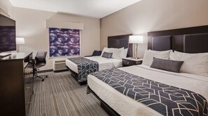 Habitación de hotel con dos camas, un escritorio, una silla, un cuadro abstracto grande y una ventana.