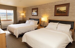 A hotel room with two beds, a desk, a chair, and a window with a view of the countryside. - Holiday Inn Spearfish - Convention Center by IHG (Spearfish)