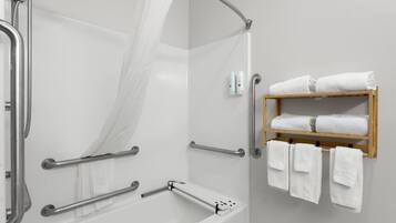 Un baño moderno con ducha, barras de apoyo, bañera y un perchero para toallas.