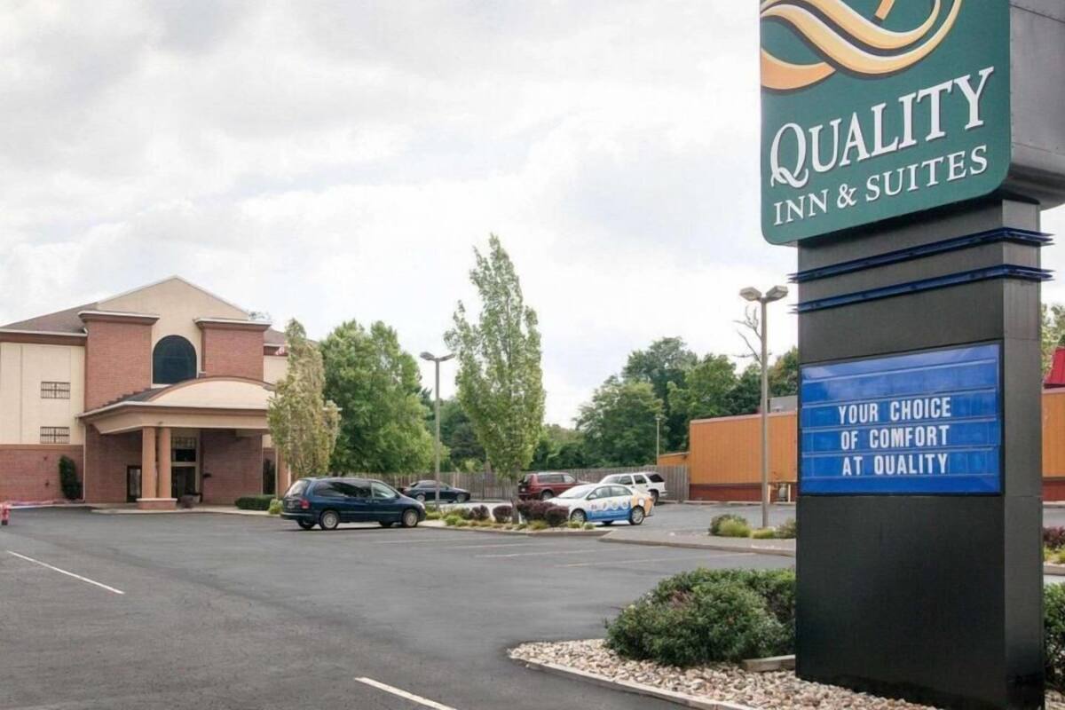 Señal de hotel con la leyenda 'Quality Inn & Suites' y el lema 'Tu elección de confort en Quality'.