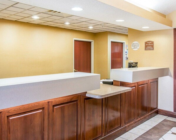 A reception area with a reception desk, a phone, and a wall-mounted sign.