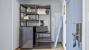A compact kitchenette with a refrigerator, microwave, and coffee maker.