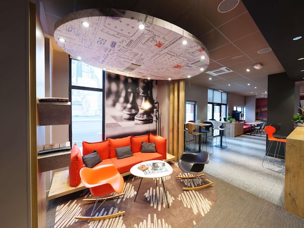 A modern lounge area with a sofa, rocking chairs, and a coffee table. - ibis Saint Quentin Basilique (Saint-Quentin)