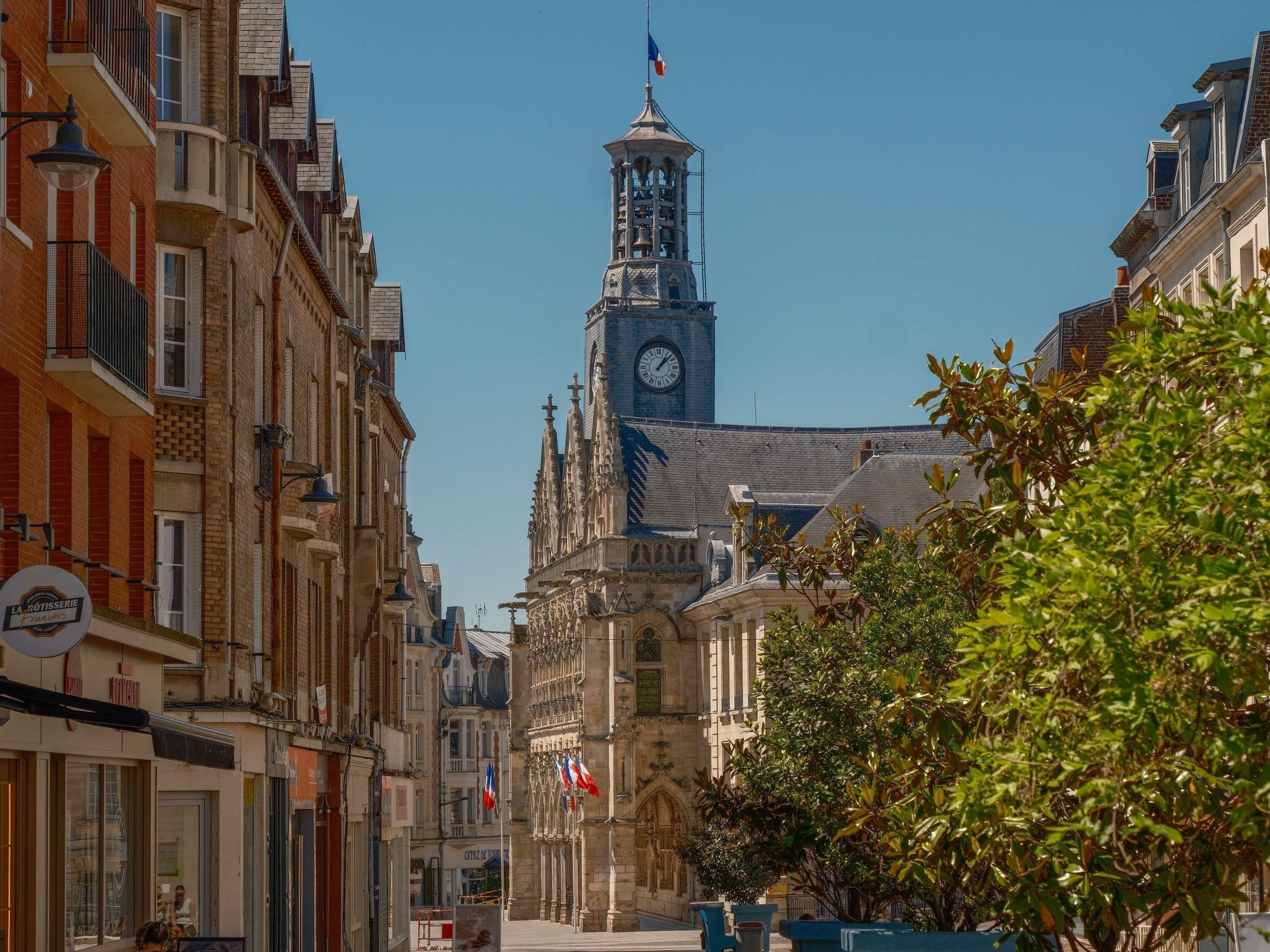 A historic building with a clock tower, classic architecture, and flags.