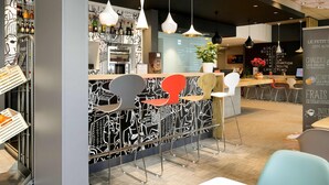 A modern cafe with a bar area, seating, and a menu board.