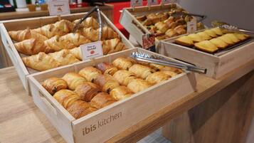 Una vetrina di pasticceria con diversi tipi di dolci, tra cui croissant e croissant al cioccolato, con etichette che riportano nomi come 'Pain au Chocolat' e 'Pain au Chocolat'.