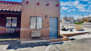A small building with a red-tiled roof, a blue door, and a sign reading "SAN MIGUEL INN."