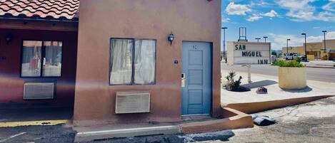 A small building with a red-tiled roof, a blue door, and a sign reading "SAN MIGUEL INN."