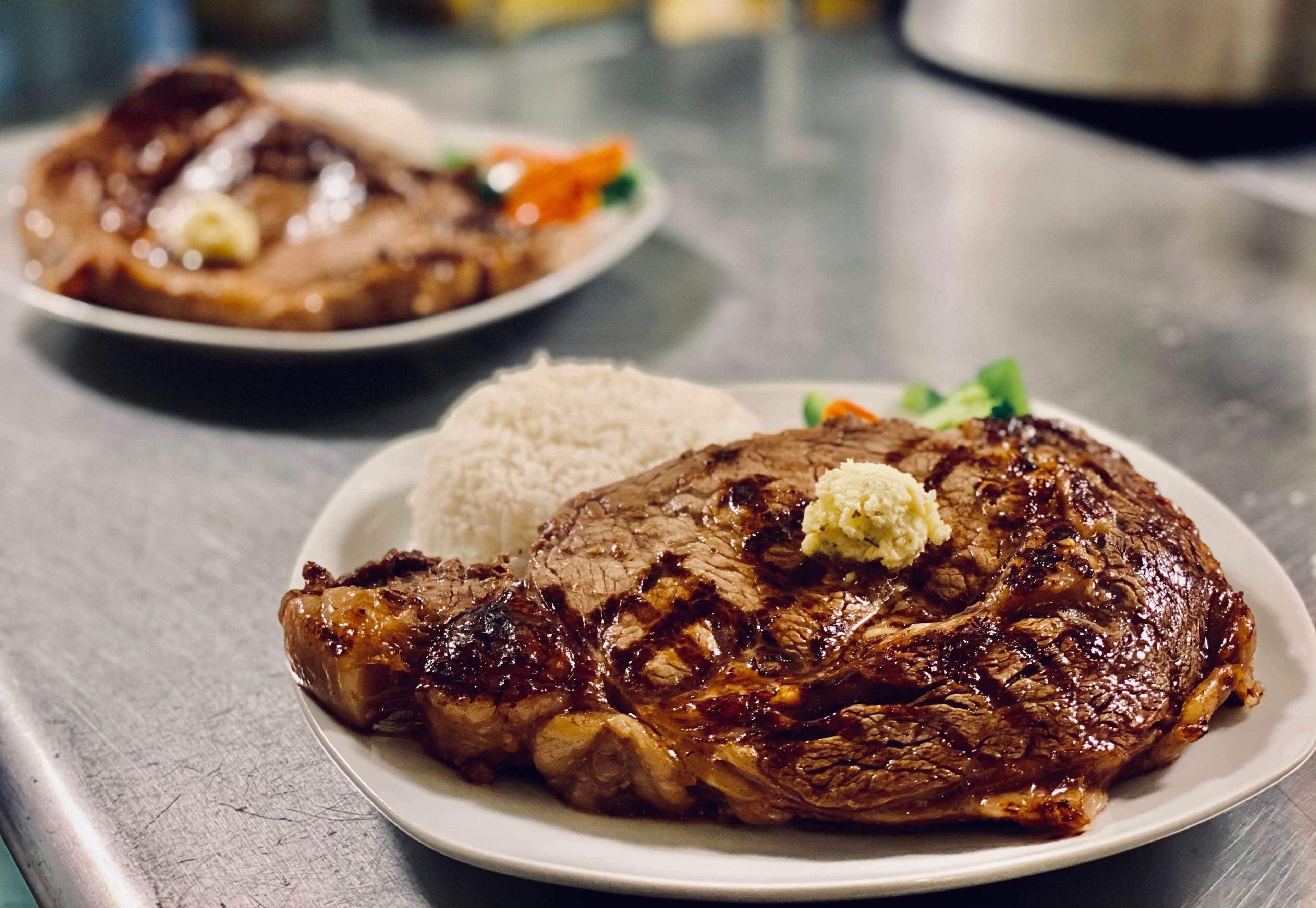 Un plato de filete a la parrilla acompañado de arroz y verduras.