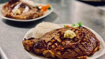 Un plato de filete a la parrilla acompañado de arroz y verduras.