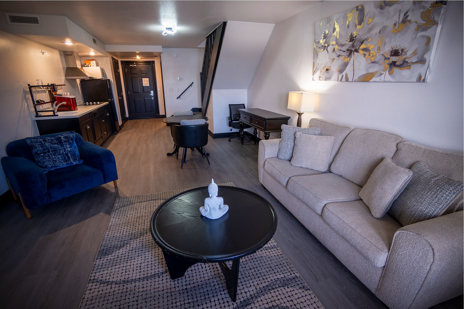 A modern living room with a sofa, a coffee table, and a dining area.