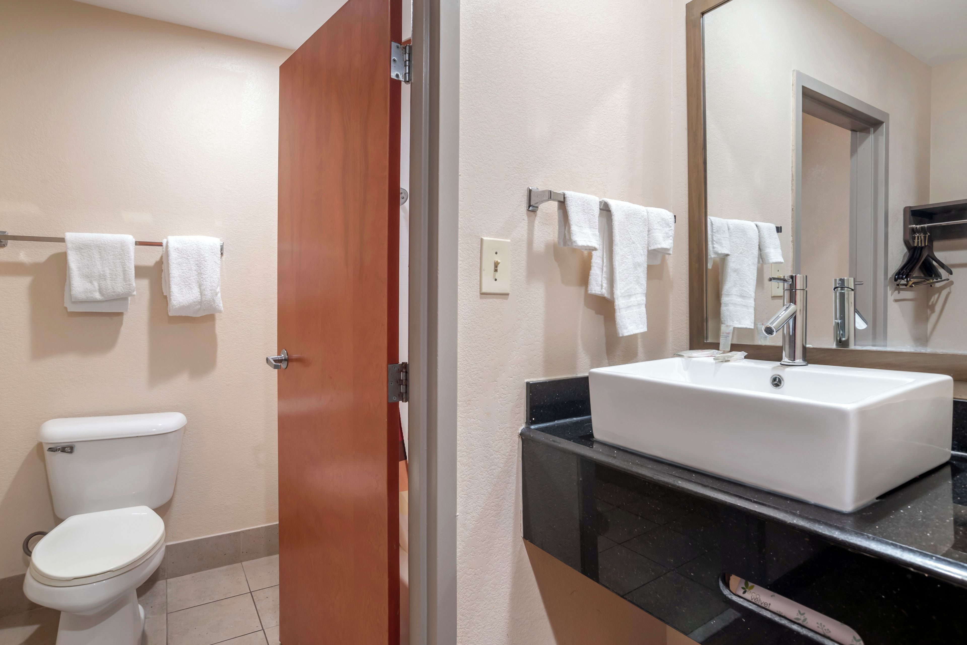Un baño con inodoro, lavabo y espejo.