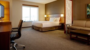 A hotel room with a bed, a desk, a chair, a sofa, and a window. - Hyatt Place Atlanta Downtown (Atlanta)