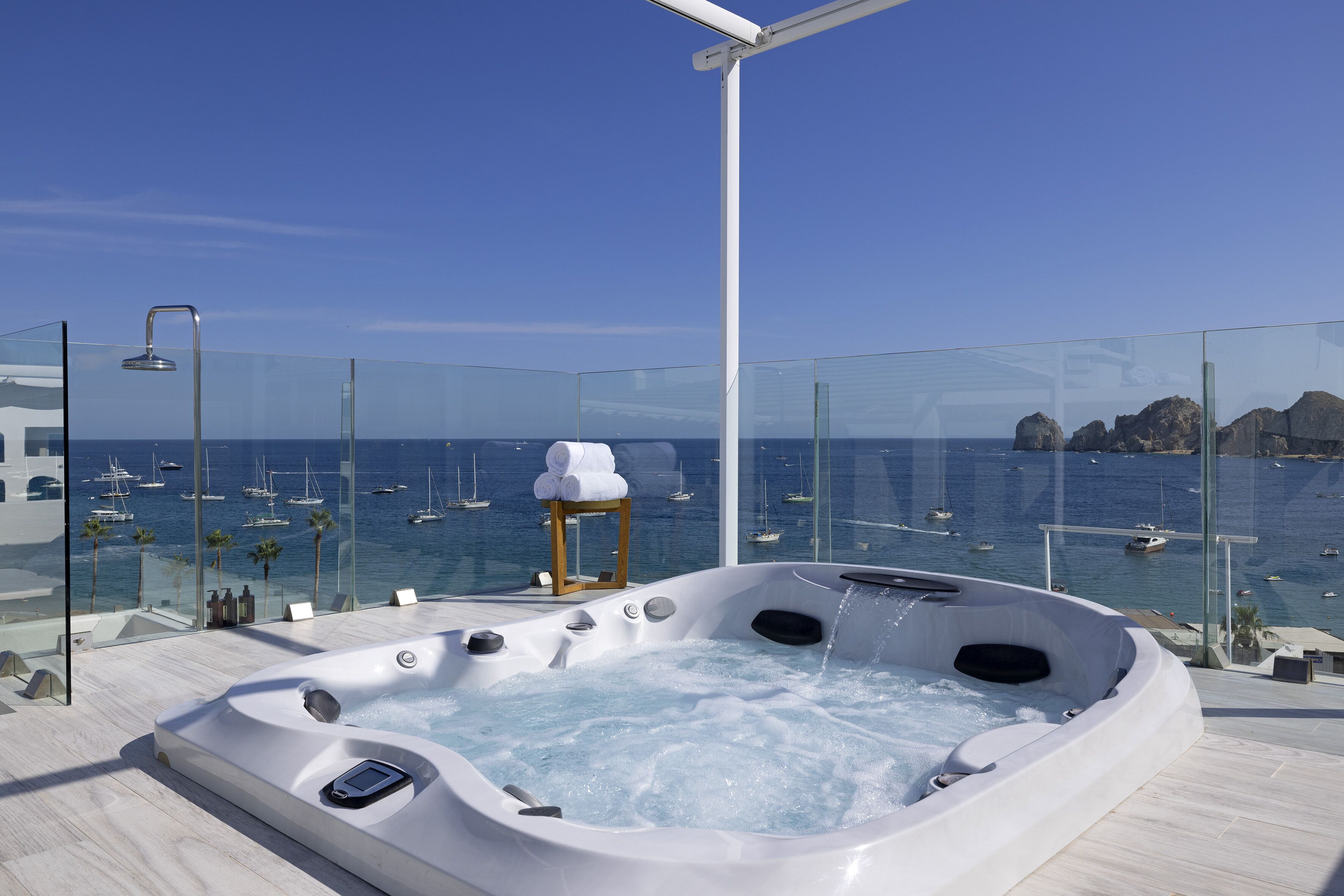 A hot tub with a view of the sea and boats.