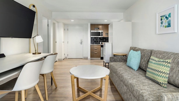 Una sala de estar moderna con un sofá, una mesa de centro y un comedor con sillas y una mesa.