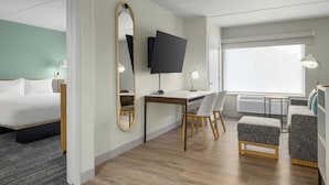 Una habitación de hotel moderna con cama, escritorio y zona de estar.