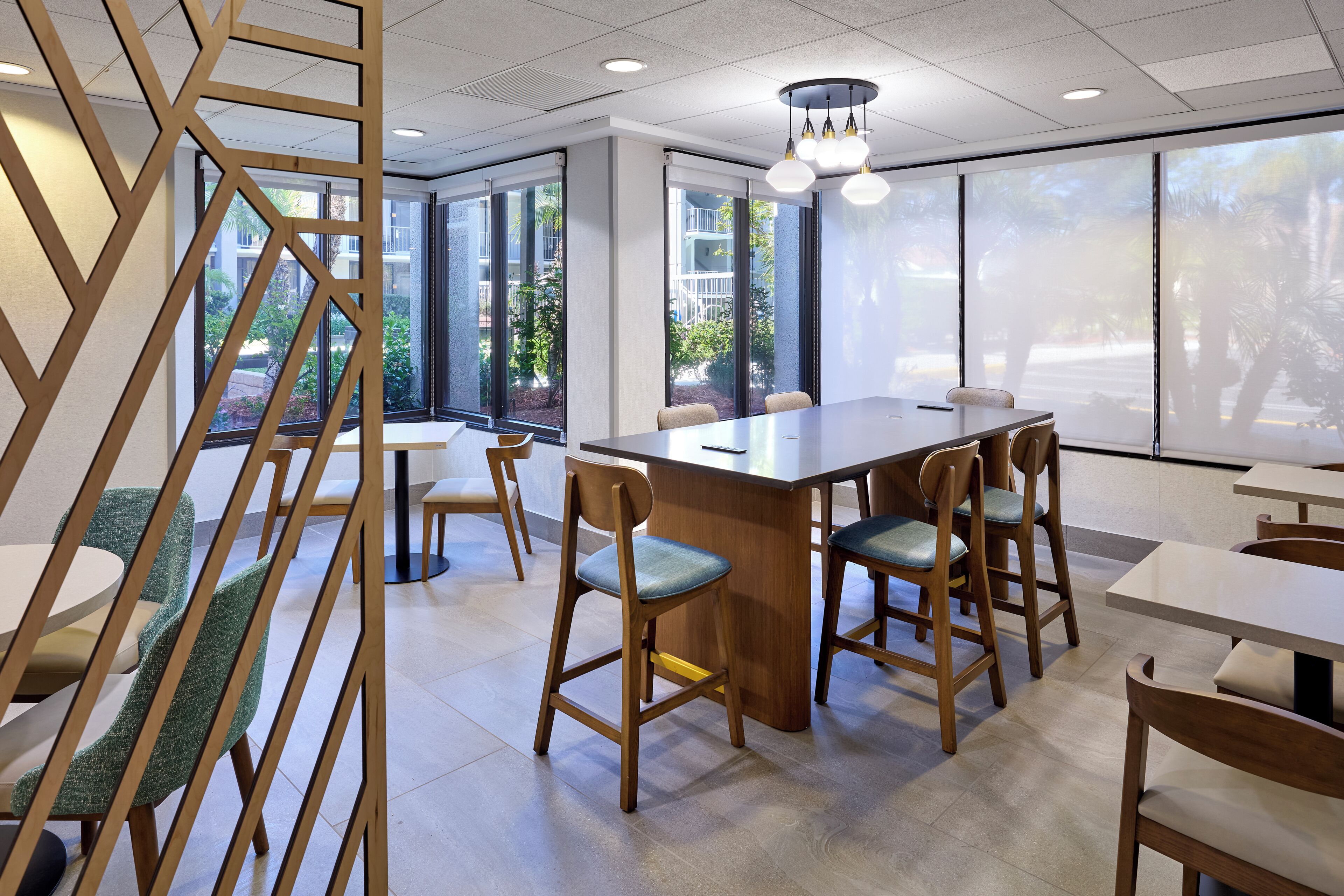 A modern conference room with a long table, chairs, and a wooden partition.